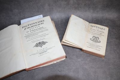 deux livres ouverts posés sur une table l'un à côté de l'autre