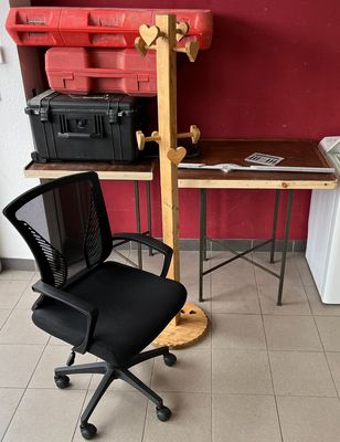 une chaise de bureau noire posée devant un mur rouge