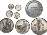 an image of a group of silver coins with different designs on them