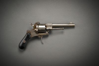 a close up of a gun on a table with a gray background