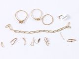 a lot of gold rings and earrings on a white surface