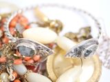 a pile of assorted jewelry on a white plate