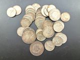 a pile of silver coins on a black surface