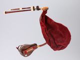 a bagpipe with a red cloth and a pair of wooden sticks