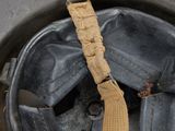 an old military helmet with a tan ribbon on a black background