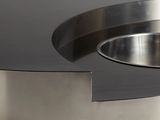 a close up of a stainless steel table with a curved edge