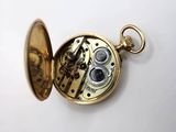 a gold pocket watch with a clock inside of it