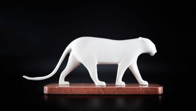 statue d'un chat blanc posée sur un socle en bois, sur fond noir