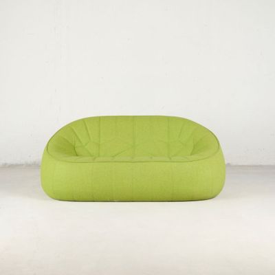 un pouf vert citron devant un mur blanc