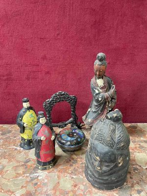 three figurines sitting on a table with a red wall in the background