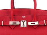 a close up of a red leather handbag on a white background