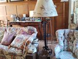 un salon avec un canapé, un fauteuil, une lampe et d'autres meubles
