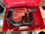 une boîte rouge contenant une perceuse, posée sur une table