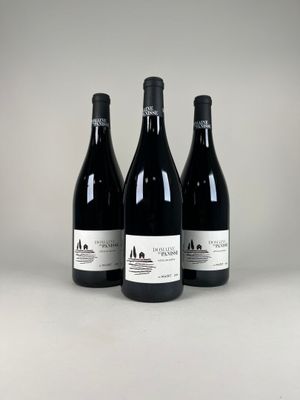 three bottles of wine sitting on top of a white table