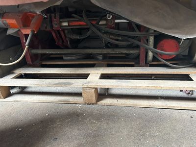 underside of a truck with a pallet underneath it on the ground
