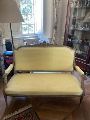 un canapé jaune dans un salon avec un tapis au sol