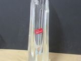 a clear glass vase with a red label on it