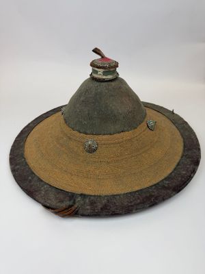 un chapeau surmonté d'un oiseau, posé sur un fond blanc