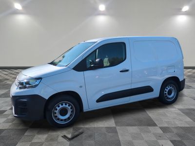 Une camionnette blanche est garée dans une pièce dont le sol est en damier.