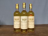 three bottles of wine sitting on top of a wooden table
