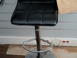 a black leather bar stool with a paper bag on it