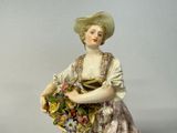 a figurine of a woman holding a basket of flowers