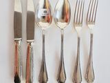 four forks, a knife, and a spoon on a table