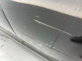 a person standing next to a car with a dirty door handle