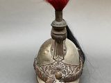 a silver helmet with a red feather on top of it