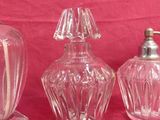 three glass vases and a soap dispenser on a pink background