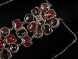 a close up of a red and black necklace on a black surface