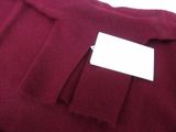 the sweater is red and has a white tag on it