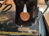 an old sewing machine with a penny on it
