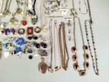 many different types of necklaces and bracelets on the table