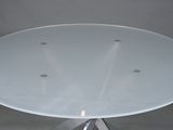 a white table with a glass top and a metal base