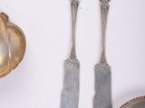 two silver spoons and two silver spoons on a white table