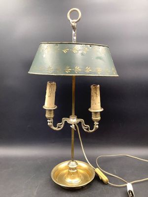 une lampe de table en laiton vieilli avec un abat-jour vert et deux bougies