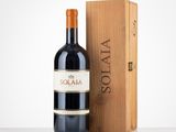 the bottle of red wine is next to a wooden box