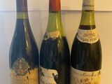 trois bouteilles de vin sont alignées sur un plan de travail