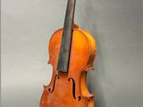 an old violin sitting on top of a table next to a gray wall