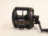 a close up of a fishing reel on a white surface