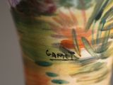 a close up of a vase with a painting on it