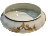 a white bowl with gold flowers and birds on it