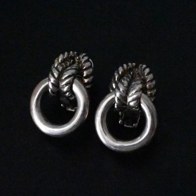 une paire de boucles d'oreilles en argent ornées d'un nœud à chaque extrémité