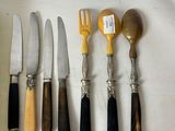 five knives, a knife, a fork, and a knife holder on a table