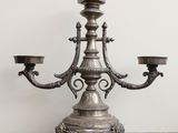 un bougeoir en argent posé sur une table, avec deux bougies