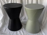 two black and green stools sitting on a white sheet