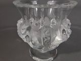 un vase en verre transparent contenant des fleurs, posé sur une table