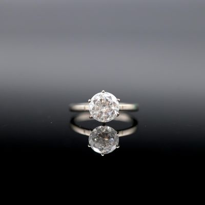 a close up of a diamond ring on a reflective surface
