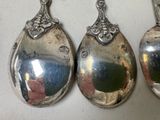 three silver spoons sitting next to each other on a table